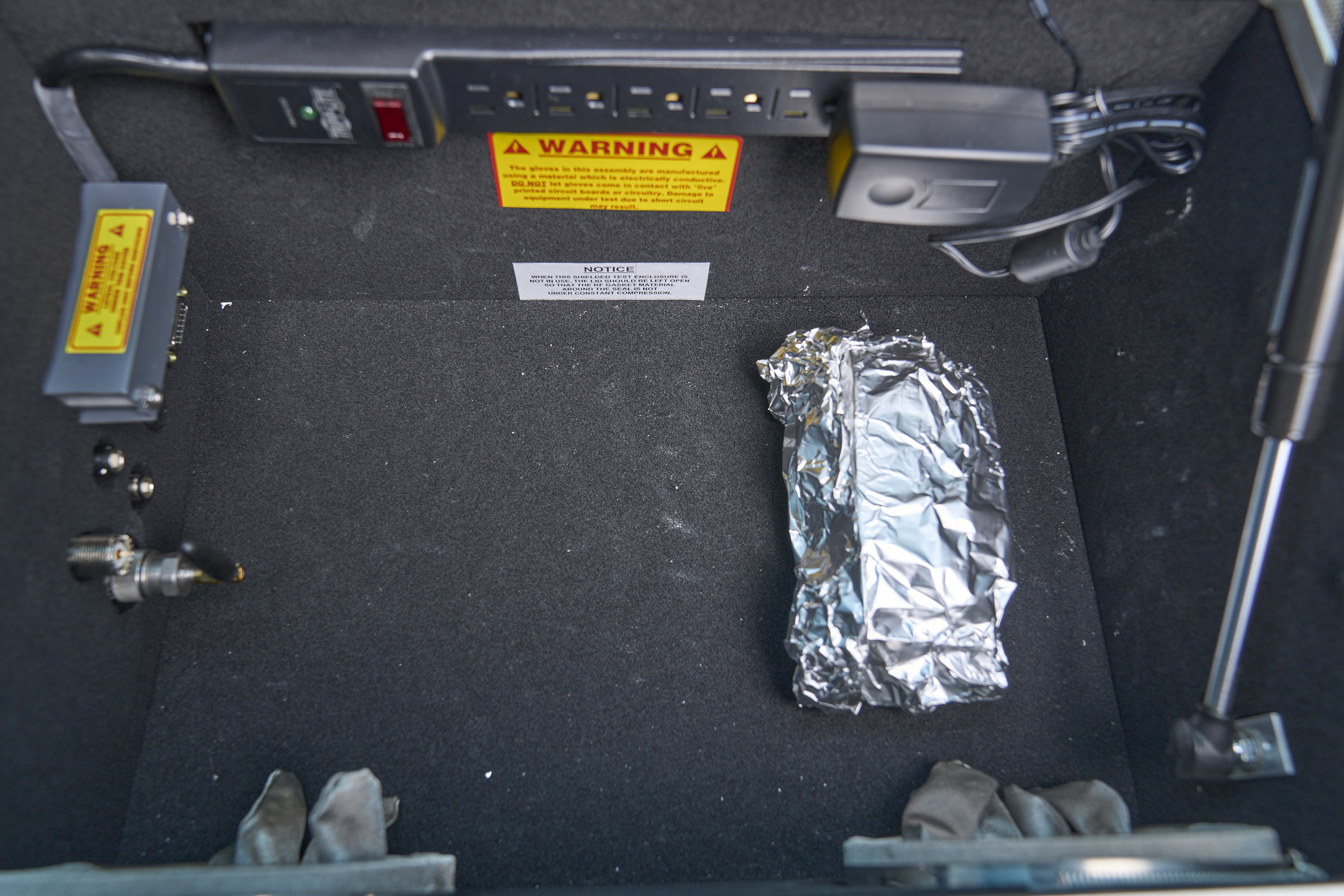 Photo: The inside of the RF test chamber, with a tinfoil package that looks like a very carefully wrapped half-eaten burrito.